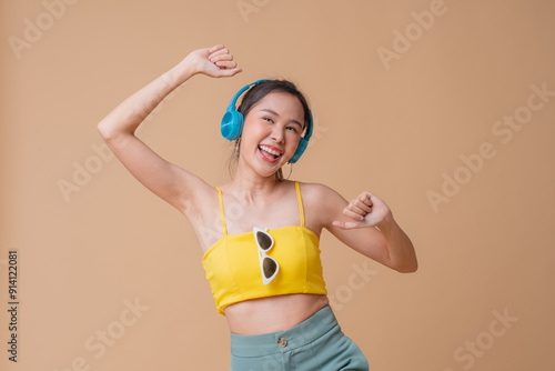 stylish active asian woman wear elegance dress and listening music headphone wellnes healthy lifestyle studio shot portrait on red color background happiness cheerful woman in action concept