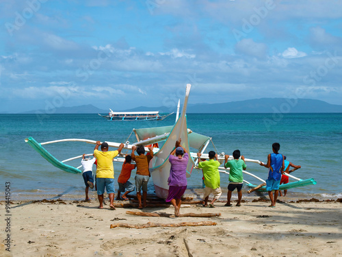 National Philippine boat. Filipino fishermen launch a traditional boat