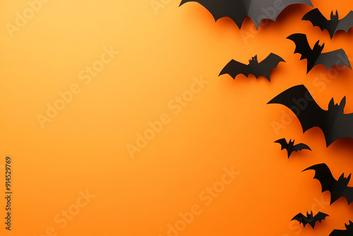 Halloween background with paper cut bats and ghosts on an orange colored background, flat lay top view copy space for text, banner design. Halloween concept. Minimalistic.