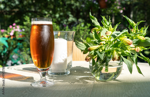 Cold dark beer on restaurant table, craft porter beer, ale froth pint glass in garden on a sunny summer day