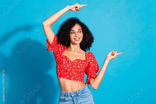 Photo of pretty young woman direct fingers empty space wear top isolated on blue color background