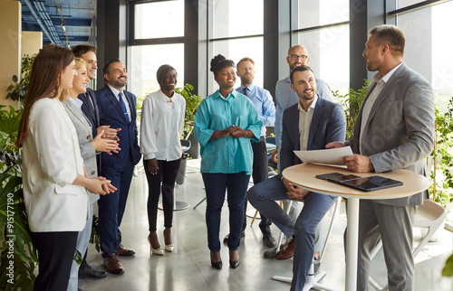 Mature serious business man, team leader coaching, mentor talks to diverse business people in office to show, explain strategy at corporate group meeting, multiethnic staff listen to boss at briefing