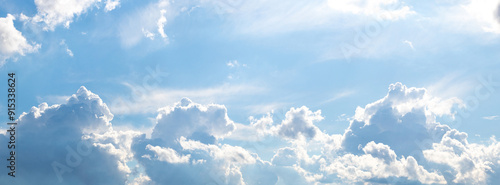 White curly clouds illuminated by the bright sun