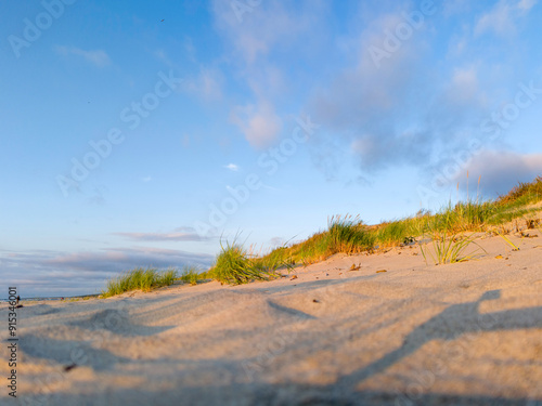 Morze Bałtyckie, zachodząca słońce i pusta piaszczesta plaża. 