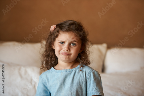 Home, portrait and kid with silly face in bedroom for playful humor, joke and funny expression. Cute, confused and little girl with emoji in house for childhood comedy, goofy and puzzled on weekend