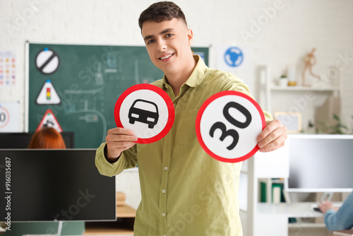 Young man with road signs at driving school