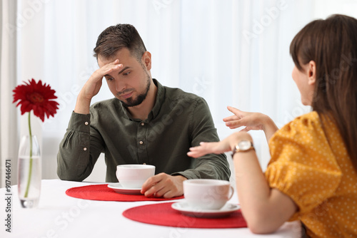 Bad date. Obsessive woman talking to embarrassed man at table indoors