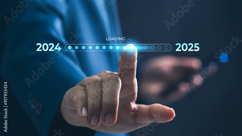 A businessman touches a digital progress bar indicating the transition from 2024 to 2025, symbolizing strategic planning, future readiness and challenge strategy for business startup