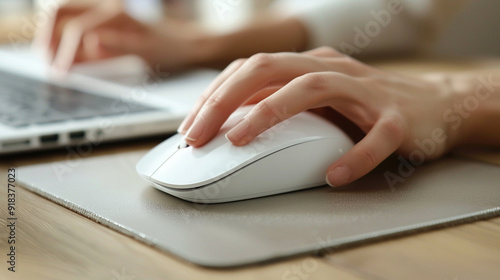 Close-up of a wireless mouse and hand, moving smoothly over a mouse pad, indicating seamless remote work