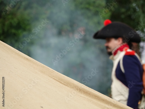 A white colored tent for setting up a field camp from the time of 1812. A hussar walks in front of a tent camp for overnight stay when Napoleon's army marched on Russia.