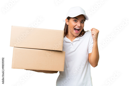 Delivery caucasian woman holding boxes isolated on green chroma background celebrating a victory in winner position