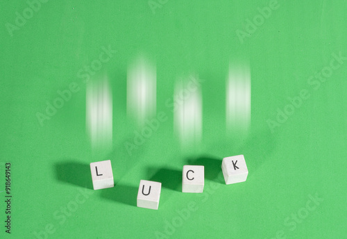 Dice forming the word Luck in English on a green background with a halo of movement. Gambling addiction.