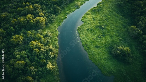 Aerial view of a winding river cutting through a lush landscape, captured by a drone.