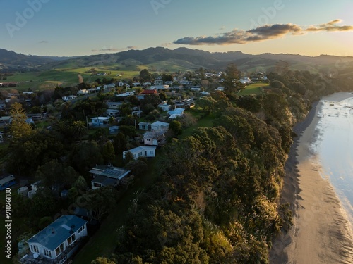 Houses and the Shoreline of the Firth of Thames at sunset at Orere Point, Auckland, New Zealand.