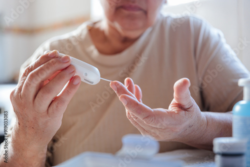 Elderly woman measuring blood sugar to monitor hypoglycemia