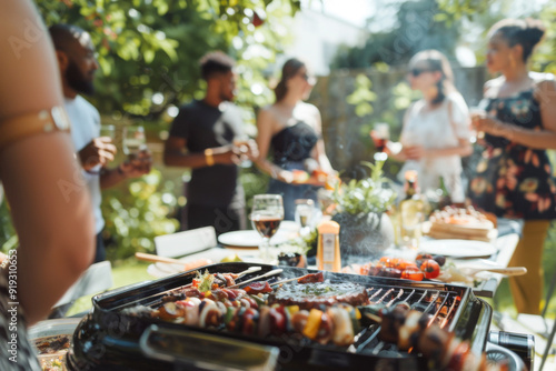 Summer backyard barbecue party with friends gathered and food on barbecue grill