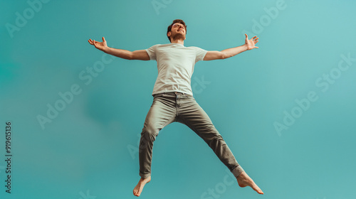 A person captured mid-jump against a blue backdrop highlights excitement, joy, and a carefree, lighthearted moment of celebration and happiness.