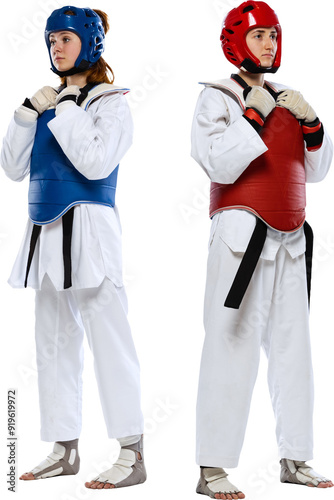 Before fight. Two young women, taekwondo athletes standing in sportswear and helmets isolated on transparent background. Concept of sport, education, skills, combat sport, martial arts