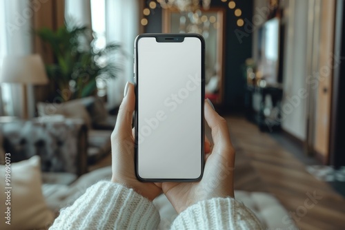 A close-up shot of a woman's hand holding a smartphone with a blank screen.