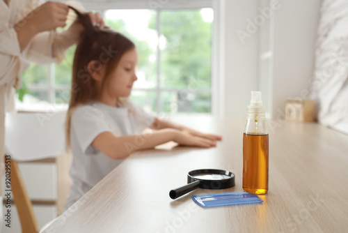 Head lice comb with magnifier and treatment for pediculosis on table in room, closeup