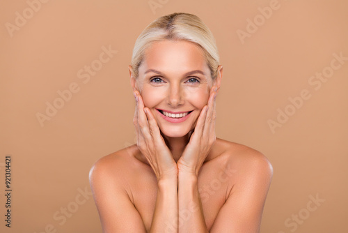 Photo of charming cute nude lady wear nothing arms hands cheekbones sheeks smiling isolated beige color background