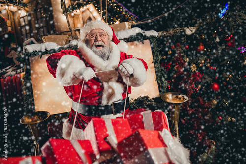 Photo of good personage santa sitting sleigh pulled by reindeer holding rope enjoying travel streets of city carrying miracle outside