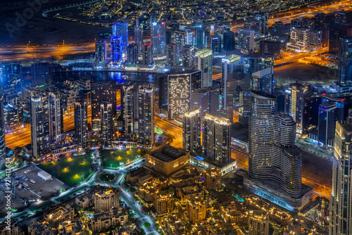 Dubai city center downtown district aerial panorama with skysrapers glowing with neon lights in the night, UAE