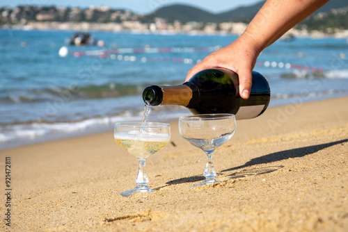 Summer time on French Riviera, two coupe glasses of champagne cremant sparkling wine on Pampelonne sandy beach near Saint-Tropez in sunny day, Var, vacation in France