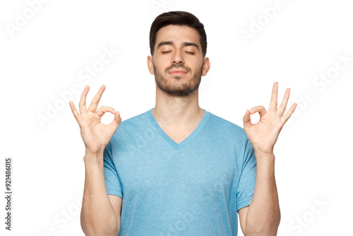 Concentrated relaxed man standing with closed eyes, having relaxation while meditating, trying to find balance and harmony. Yoga and meditation concept