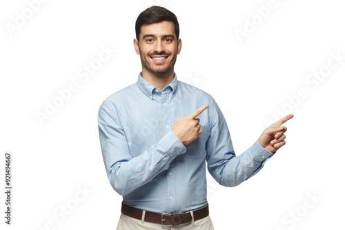 Smiling businessman pointing right with two hands and looking at camera