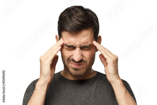 Portrait of young man suffering from severe headache, pressing fingers to temples with closed eyes