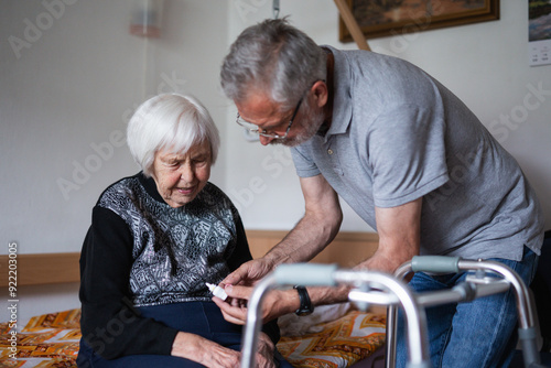 Man is helping an elderly woman with everyday tasks, helping with technology, setting video face time with her family using smart phone