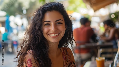 A beautiful Cypriot woman. Cyprus. A beautiful Cypriot woman. A cheerful young woman with curly hair smiles brightly while enjoying a sunny outdoor caf√© setting. #wotw