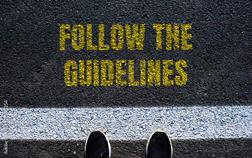 Follow the guidelines message written on asphalt road. Conceptual follow the guidelines symbol. Copy space.