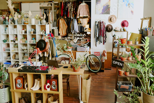 Chic boutique showcasing an assortment of fashion accessories, clothing, and numerous house plants decorating interior. Creating a cozy ambiance with neatly organized items throughout