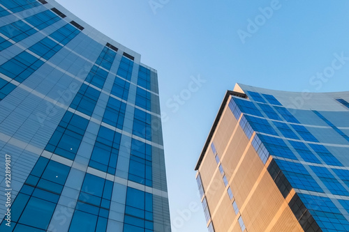 Architectural details of exterior design of skyscraper building in urban area with blue sky background. Abstract pattern of building, lines and curves.