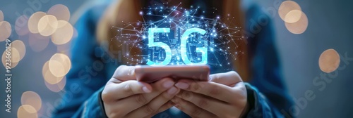 Close-up of hands holding a smartphone with a glowing 5G symbol, representing fast mobile internet technology and connectivity.