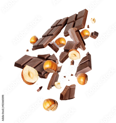 Levitation of a broken dark chocolate bar with hazelnuts in the air isolated on a white background