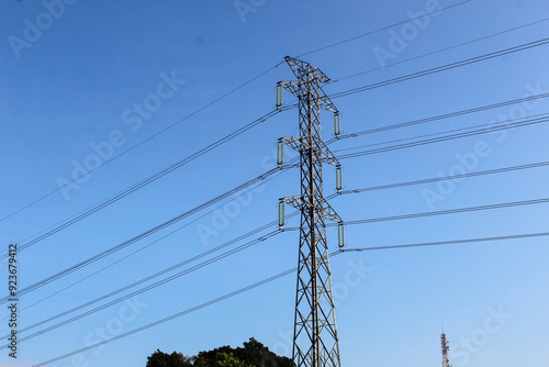 Selective focus of High voltage towers or power line tower with a background of bright blue sky with clouds during the day