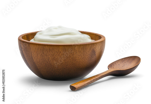 A bowl of yogurt on a white background with a wooden spoon next to it