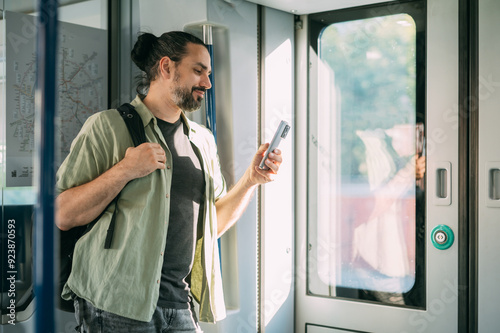 A Caucasian man with a phone rides on the train, in the skytrain, in the subway. Urban transport.