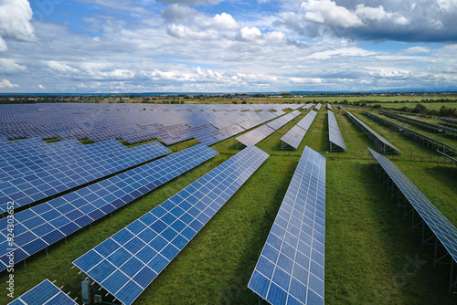 Aerial view of big sustainable electric power plant with many rows of solar photovoltaic panels for producing clean electrical energy. Renewable electricity with zero emission concept