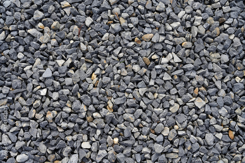 A close-up photograph showcasing a bed of small, grey stones arranged compactly together, emphasizing texture, pattern, and uniformity, suitable for various uses.