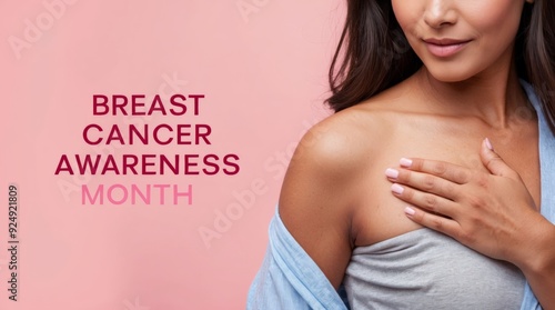 Woman touching her breast, ribbon symbolizing breast cancer, with phrase Breast Cancer Awareness Month, light pink background.