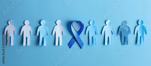 Prostate cancer awareness concept with blue ribbon heart and paper men s silhouettes on a blue background ideal for copy space image