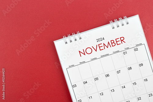 November 2024 desk calendar on red background.