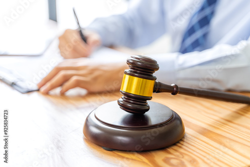 Close up of court gavel with blurred working male lawyer in background