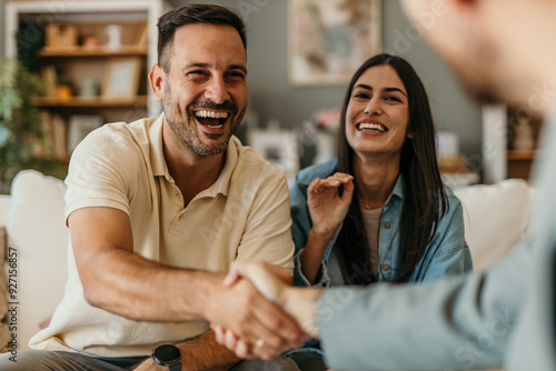 The young happy couple and an agent in a new property, or a professional psychologist advising spouses helping them restore marriage, and handsaking