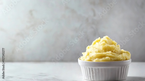 A clean white marble background contrasts with a white bowl of bright and buttery, lumpy mashed potatoes with a big space on it for textual or background use, Generative AI.