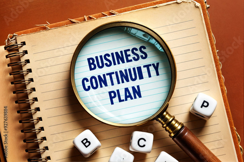 A magnifying glass over a notebook with the word text "BCP" acronym abbreviation of Business Continuity Plan, suggesting a focus on business preparedness.